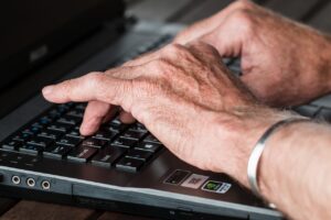 woman's veiny hand typing on the keyboard
